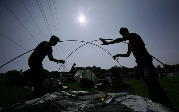 Glastonbury arrivals: Festival goers set up their tent in a camping area at Glastonbury festival