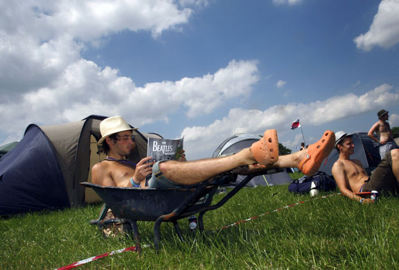 Glastonbury arrivals: A camper rests in a wheelbarrow at the Glastonbury festival 