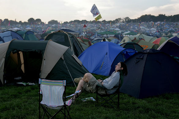 First day at Glastonbury: A reveller taking it easy in a sea of tents at Glastonbury