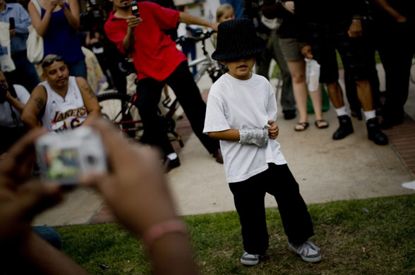 Jackson lookalikes: A fan dances to a Michael Jackson song outside the UCLA medical centre