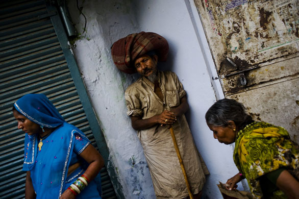 26 June 2009: New Delhi, India: A beggar stands against a wall
