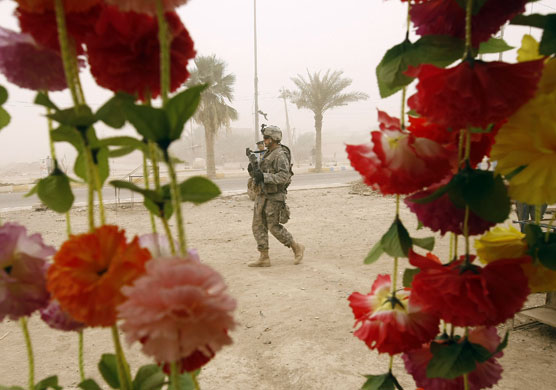 29 June 2009: Khan Bani Saad, Iraq: A US soldier walks alongside an Iraqi police officer