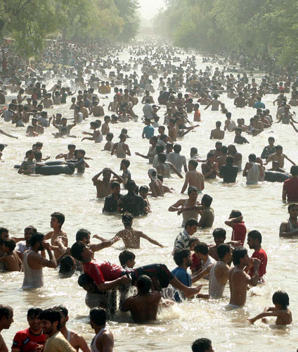 29 June 2009: Lahore, Pakistan: People cool off in a canal