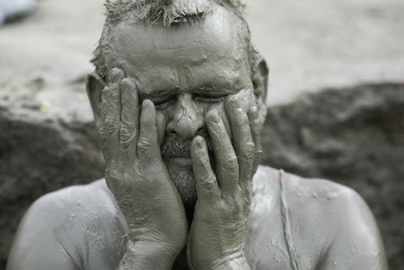 3 June 2009: Allahabad, India: A Hindu devotee smears his body with mud