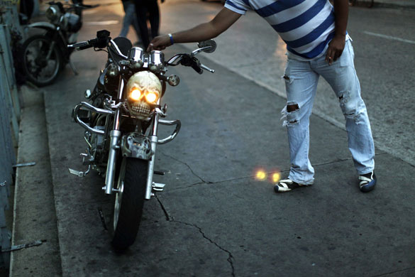 3 June 2009: Guatemala City, Guatemala: A man stands next to his motorcycle