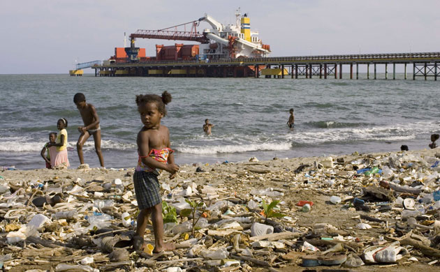 Garbage: A girl stands on garbage on the beach in Haina in the Dominican Republic