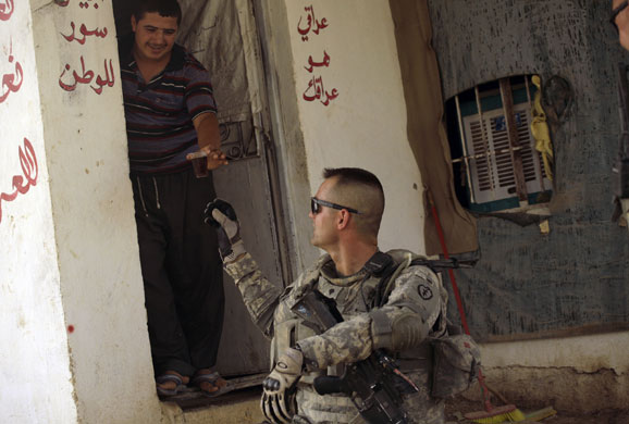 Iraqi army handover: An Iraqi youth serves tea to U.S. Army soldier