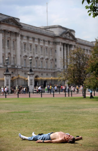 UK weather update: A man lies in a park close to Buckingham Palace