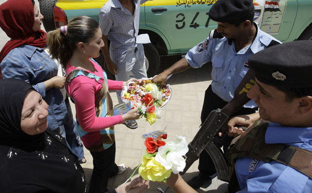 Iraq: Members of the Communist Party distribute sweets to Iraqi security forces