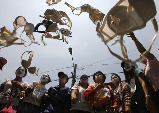 24 hours in pictures: Dismissed workers of Triumph International Philippines throw bras in air