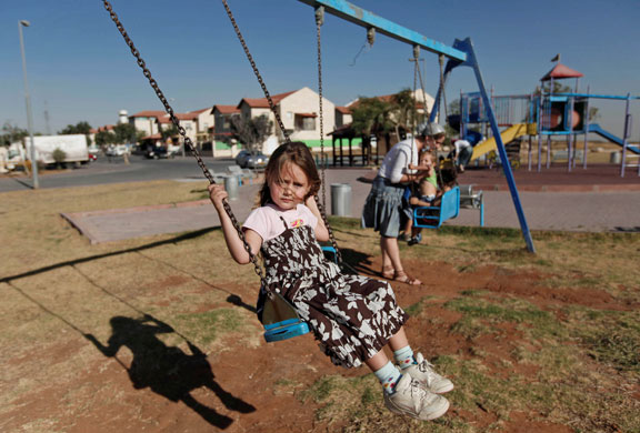 24 hours in pictures: Israeli children play on a swing set at a playground in the West Bank
