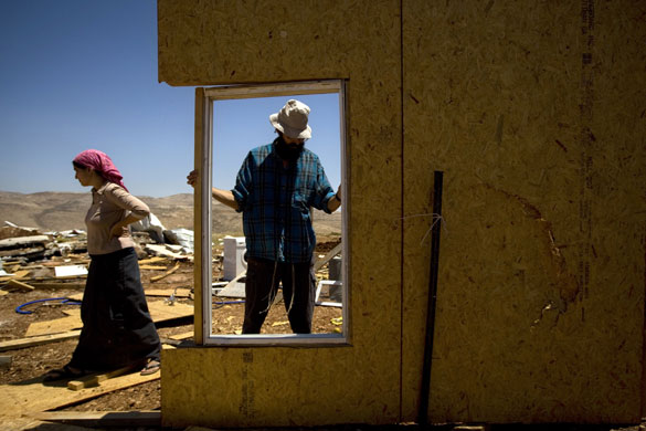 24 hours in pictures: Jewish settlers rebuild their destroyed structures