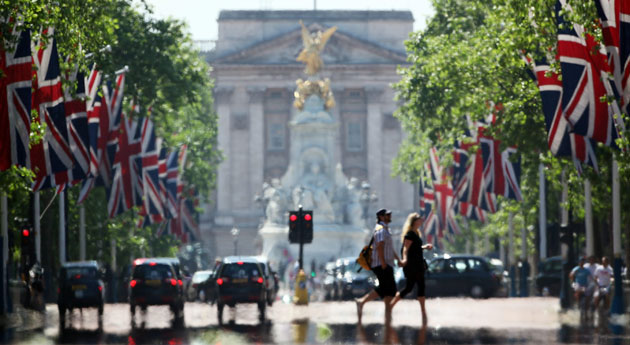 Week in Business: A couple walk through a heat haze across The Mall