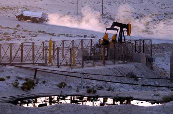 Week in Business: A truck passes an oil pump in the desert oil field of Sakhir, Bahrain.