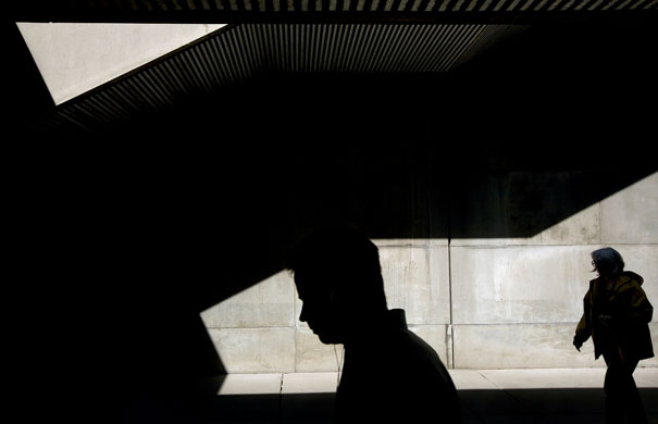24 hours: Pedestrians walk through shadows near Toronto's City Hall
