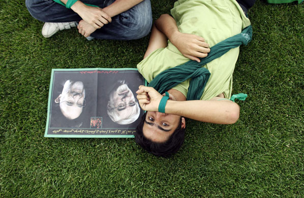 24 hours in pictures: A supporter of Mirhossein Mousavi next to his picture at a rally in Karaj