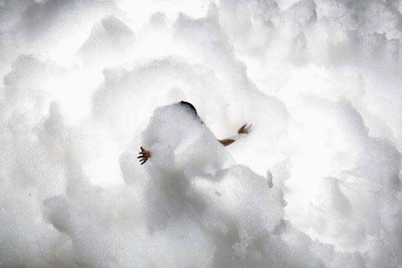 24 hours in pictures: An Israeli student dances in foam as part of a gay pride event Israel