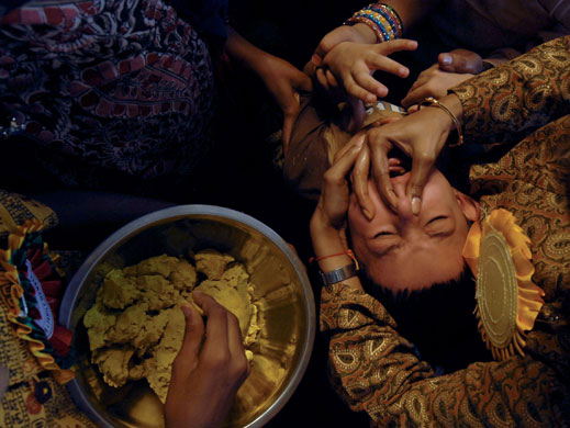 9 June 2009: Hyderabad, India: A boy swallows a live fish dipped in medicine