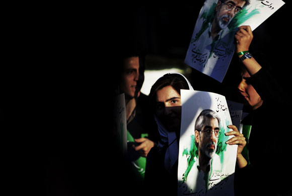 9 June 2009: Tehran, Iran: A female supporter displays a poster of Mir Hossein Mousavi