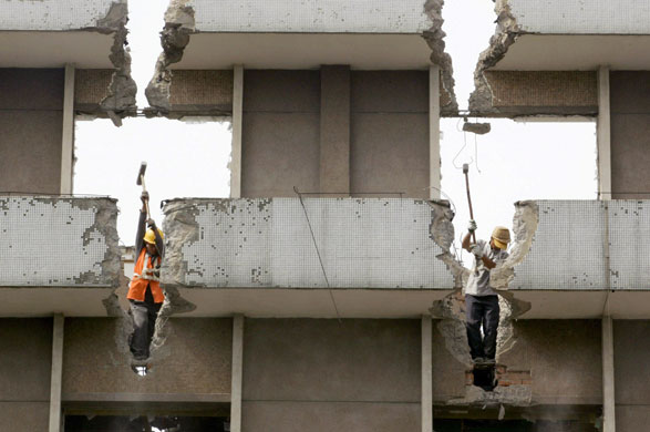 9 June 2009: Kunming, China: Labourers demolish an old house at a construction site