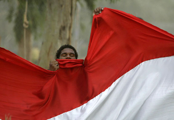 1 July 2009: Baghdad, Iraq: A man kisses a flag as he celebrates the US withdrawal