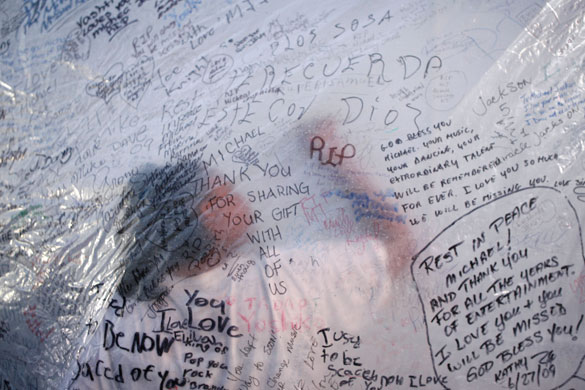 1 July 2009: New York, US: A Michael Jackson fan signs her name onto a wall