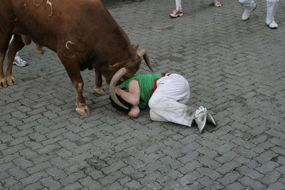Pamplona bull running: A runner is gored