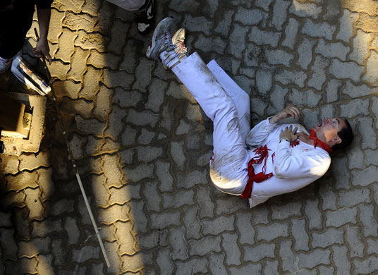 24hours in pictures: Man after been gored by a Miura fighting bull at San Fermin festival Spain