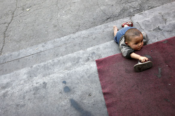 24hours in pictures: An Uighur baby crawls on his hands and knees on stairs