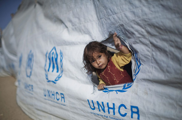 Refugees return to Swat: A young girl waits to board a bus