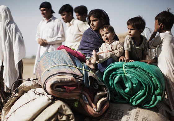 Refugees return to Swat: People sit with their belongings at the Yar Hussain UNHCR camp