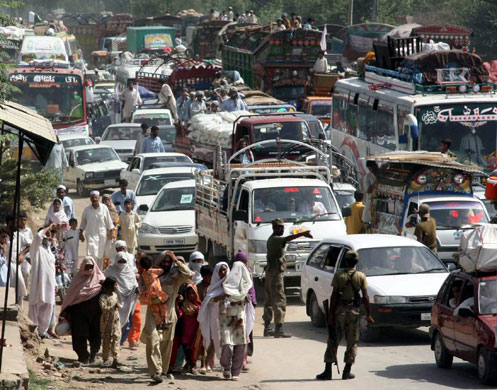 Refugees return to Swat: Refugees cross Shergarh military checkpost as they return to Swat region
