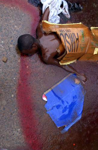 Charles Taylor: 2003: A man lies dead on a street in Monrovia