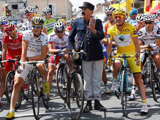 tour de france stage 11: Yellow jersey holder Rinaldo Nocentini with a man dressed as a postman
