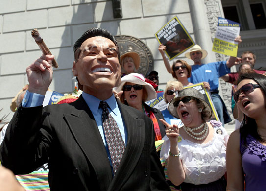 Week in Business: A protester dressed as California governor Arnold Schwarzenegger is heckled