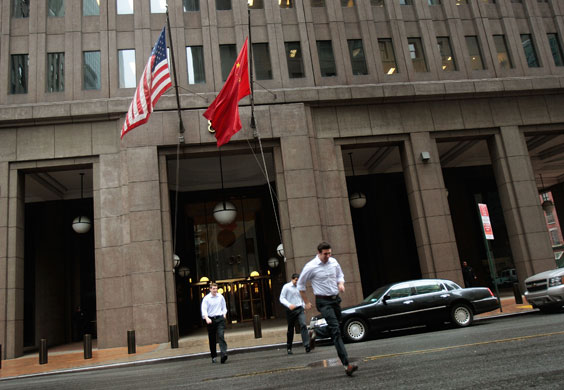 Week in Business: People run in the rain outside the Goldman Sachs headquarters in New York