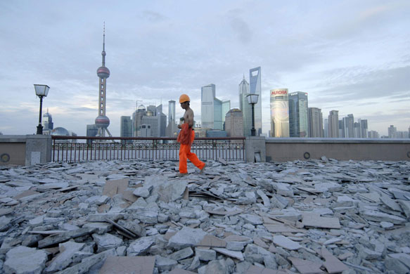 Week in Business: A labourer walks on the bank of the Huang Pu River in Shanghai. 