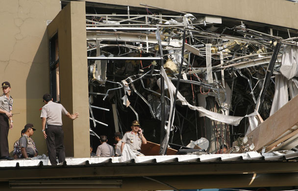 Jakarta bombings: Police officers inspect the damage at the Marriott hotel in Jakarta