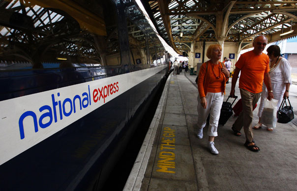 Week in Business: Passengers walk past a National Express East Coast line train