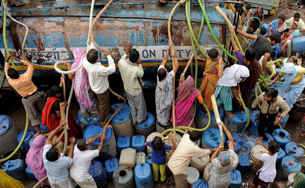24hours in pictures: Indian residents scramble to fill water from a water tanker