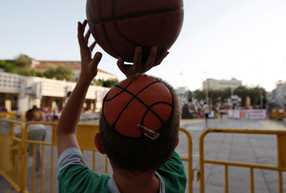 24hours in pictures: An Israeli boy with a basketball kippa plays with a basketball