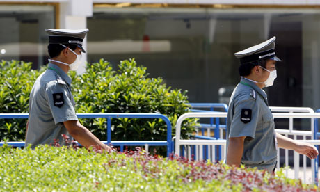 Guards enforce a swine flu quarantine for foreign students at the Yanxiang Hotel in Beijing, China.