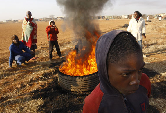 South Africa violence: Some of the hundreds of protesters stand around a fire in Johannesburg