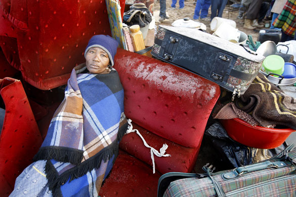 South Africa violence: An elderly woman sits with her belongings during protests in Johannesburg