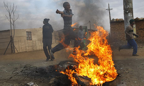 South African residents of Balfour run during riots with police after protests erupted in townships