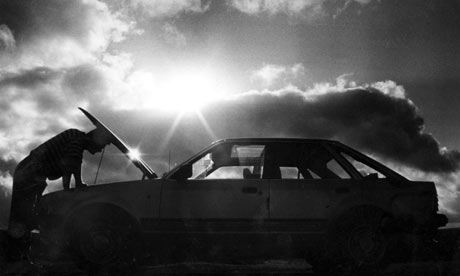Man looking under the bonnet of a Ford Escort