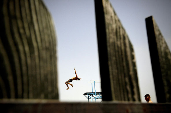 26 July 2009: Milosevo, Kosovo: A boy jumps into the water in a swimming pool