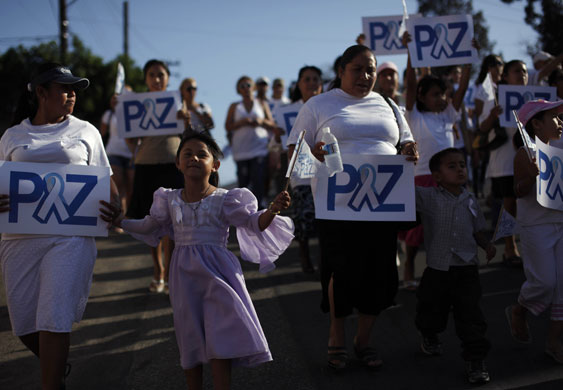 27 July 2009: Tijuana, Mexico: People hold banners with the word 'peace' during a march