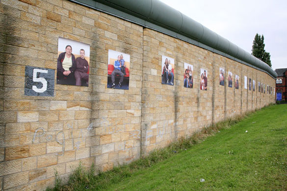 Casey Orr: A line of photographs on an exterior prison wall