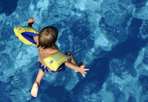 24 hours : Duesseldorf, Germany: A boy wearing water wings jumps into a pool 